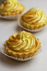 Tasty lemon tart with meringue on light background