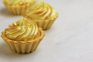 Tasty lemon tart with meringue on light background