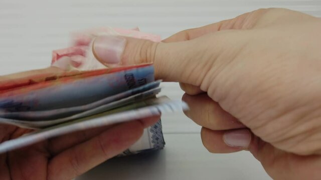 Hands counting Saudi Arabia money, five hundred to fifty riyals