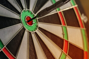Close up Arrow hitting center on dartboard the target, the game focuses on success, planning to be smart concept.