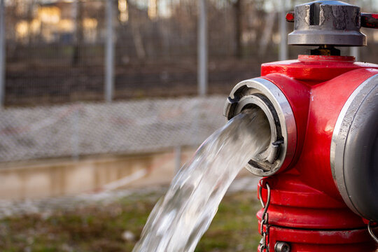Close up of Water flowing from in open red fire hydrant