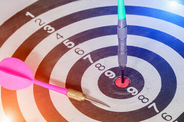 Closeup Darts hitting center target on Dartboard with bokeh, concept Business investment that rely...