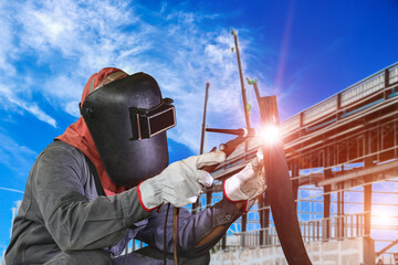 Male worker wearing protective clothing of repair pipe argon welding industrial construction site background.