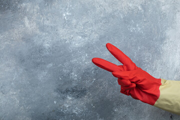 Female wearing red protective gloves on marble background