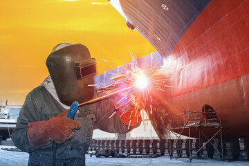 Welder is welding close up, a large cargo ship repair in dry dock yard shipyard Thailand