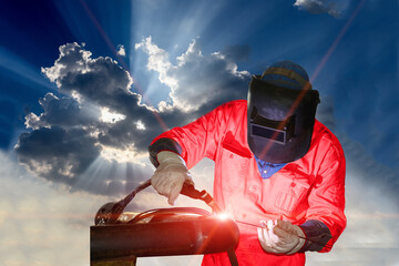 Industrial worker at the factory welding close up by Tig weld, light through the clouds concept