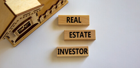 Real estate investor symbol. Wooden blocks with words 'Real estate investor' near miniature house....