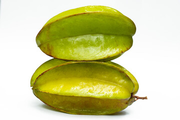 Two green carambola fruit on a white bg