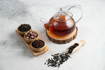 Fototapeta na wymiar A glass teapot with wooden bowls of loose teas