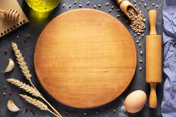 Pizza or bread cutting board with bakery ingredients for homemade baking on table