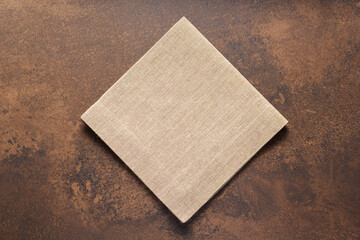 Folded burlap linen fabric tablecloth at stone surface of table