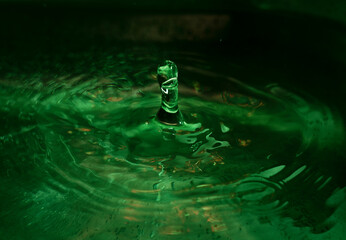 gota de agua golpeando en charco verde