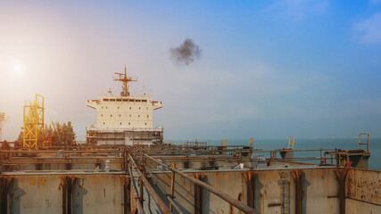 Shipyard, Container mooring alongside ship during repair in shipyard and scaffolding installed on cargo hold on accommodation with bridge deck background.