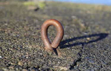 A  close up view of a metal mooring eye bolt in the harbour wall at New Quay, Ceredigion, Wales.
