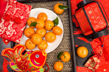 On the table are kumquats, red envelopes and lanterns