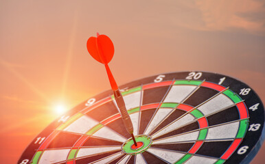 Arrow hit the target with light on sunset background, the game focuses on success, planning to be...