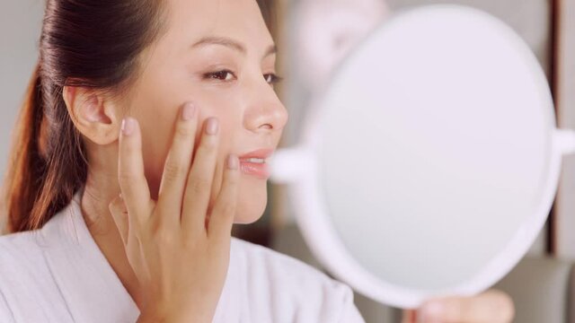 Happy attractive asian woman apply skincare cream on face and body.Female  hand touch face  and smooth applying cream and lotion for rejuvenation, beauty perfect with wellness, skin care .