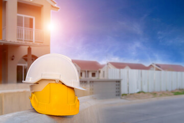 White and yellow hard hat safety helmet on wooden in construction site.