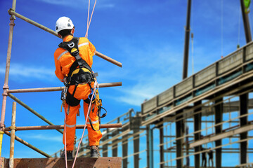 Worker on the high scaffolding wear equipment protective safety harness and ppe on structure steel factory site project background.