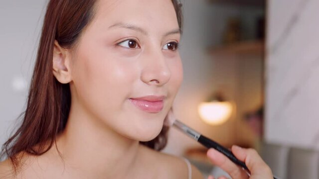 Happy attractive asian woman apply skincare cream on face and body.Female  hand touch face  and smooth applying cream and lotion for rejuvenation, beauty perfect with wellness, skin care .
