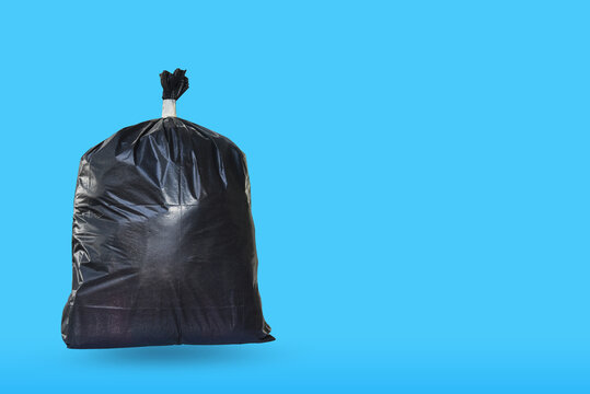 Garbage bag isolated on blue background as a symbol of waste management and environmental issues as throw away black plastic sack full of dirty smelly trash and useless junk with clipping paths