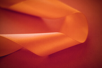 Branding, holidays and luxe brands concept - Abstract curly silk ribbon on orange background,...