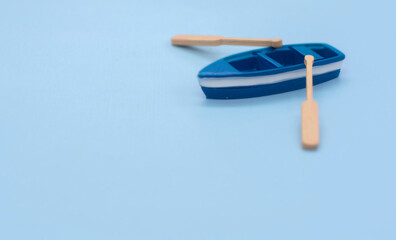 one blue toy boat. small boat models with oars