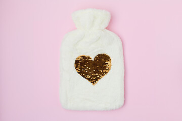 winter flat lay with hot water warmer on pink