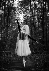 Fototapeta premium Young ballerina in ballet costume dancing in city park, feeling breath of big city life and freedom 