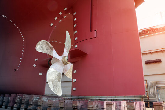 Close up Big Propeller and rudder at stern of big ship during maintenance at floating dry dock in shipyard