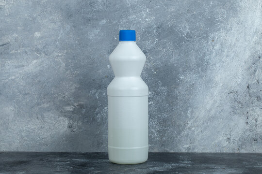 White container of bleach on marble background