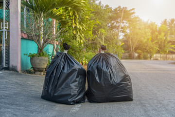 Pile of black garbage bag on footpath at side rode in city pollution trash