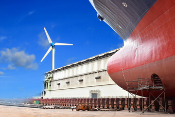 Old forward and Bulbous bow ship, Large ship rear view under Repair at floating dock in shipyard.