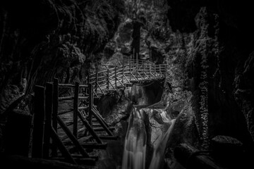 Black and white and tilt shift effect of stalactites above the walkway in caves carved out of sandstone, Caglieron caves, Veneto, Italy