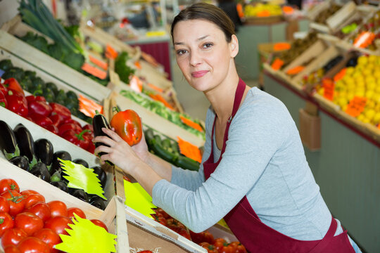 portrait of adult female selling fruits and vegetables in store