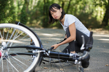 Fototapeta na wymiar annoyed woman pumping up a bike tire