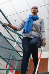 blind person with long cane going down stairs