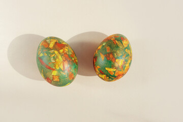 Easter eggs painted in trendy colors of green, yellow and red. Mosaic pattern. Light background, top view, myimalism, copy space.