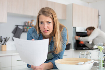 woman looking at letter with an expression of dismay