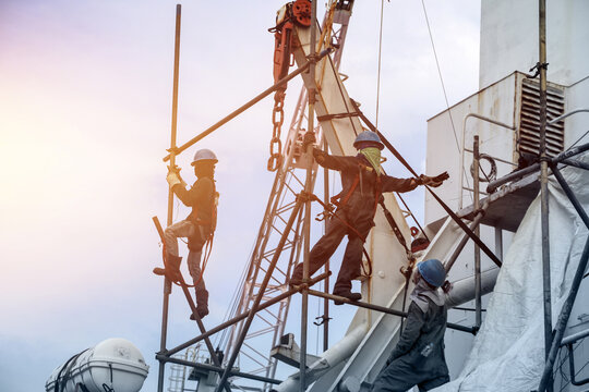Constructions workers working on scaffolding at a high level for installation staging by wear equipment protective PPE, the standing set must in clude a safety belts heavy industry concept