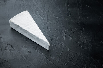 Slice of brie farmhouse creamy soft cheese, on black background  with copy space for text