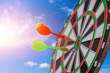 Close up of Success Red and Green Dart target  on center of dartboard with arrow on sky background,...