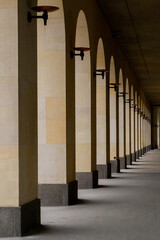 An arched passage near the building. Light passes through the arches..