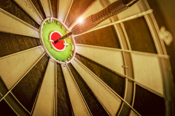 Red three darts arrows in the target center business goal concept, the game focuses on success, planning to be smart concept on retro filter tone