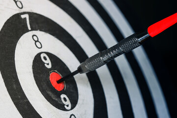 Close up shot of the dart arrow hit on bull eyes of dartboard to represent that the business...