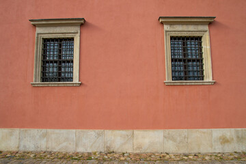 Two windows on a red wall..