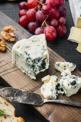 Tasty blue cheese, on black wooden table
