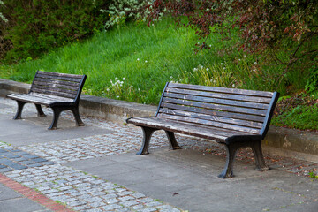 Two benches in the park near the green grass..