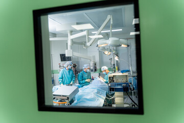 Fototapeta na wymiar Medical team performing surgical operation in bright modern surgery room. Operating theatre. Modern equipment in clinic. Emergency room.