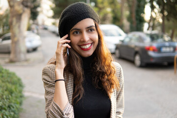 Portrait of a gorgeous Persian women talking on the mobile phone with a big smile in the urban city 